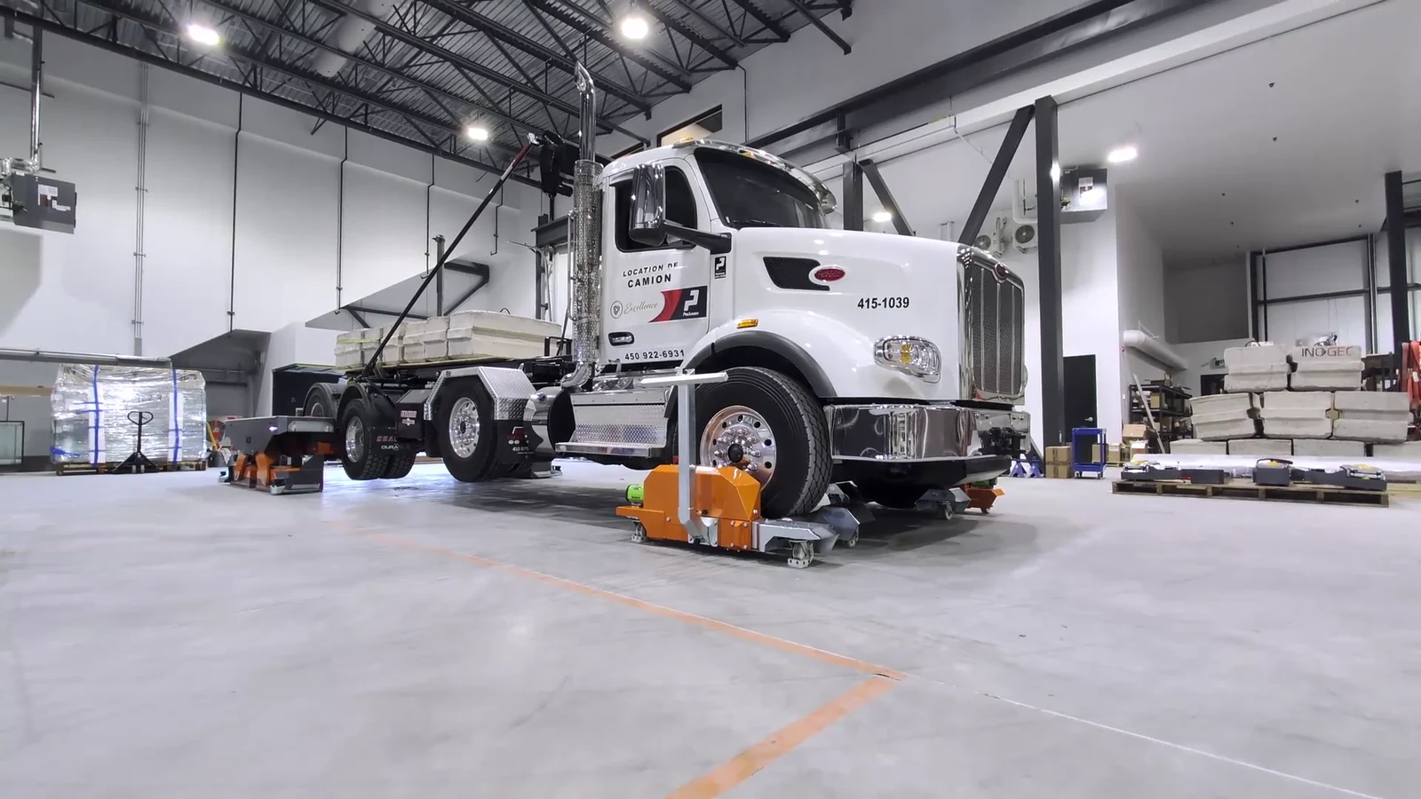 Three-quarter view of RTM-002 handling a truck loaded with concrete blocks
