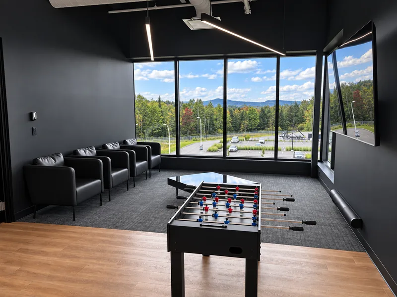 INOGEC lounge with armchairs, foosball, and large windows